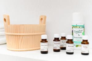 a shelf with four bottles of essential oils and a basket at Pension Nordkap in Bensersiel