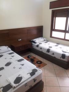 1 dormitorio con 2 camas con vacas en Residence Las palmas, en M'diq