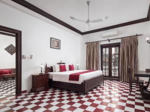 a bedroom with a bed and a checkered floor at Chateau d'Angkor La Residence in Siem Reap
