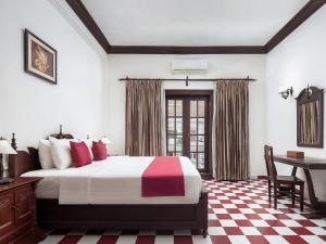 a hotel room with a bed and a desk and a table at Chateau d'Angkor La Residence in Siem Reap