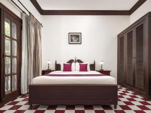 a bedroom with a bed with red and white checkered floors at Chateau d'Angkor La Residence in Siem Reap