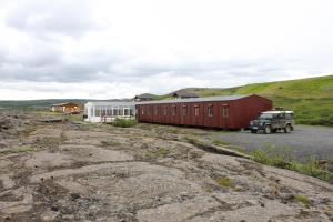 a truck parked in front of a red building at Hlíd Hostel in Myvatn