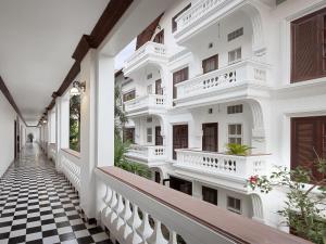 a corridor of a white building with a checkered floor at Chateau d'Angkor La Residence in Siem Reap