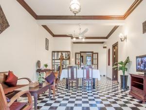 a dining room with a table and chairs on a checkered floor at Chateau d'Angkor La Residence in Siem Reap