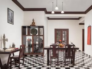 a dining room with a table and chairs on a checkered floor at Chateau d'Angkor La Residence in Siem Reap