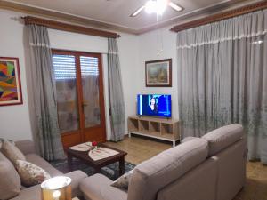 un soggiorno con divano e TV di CASA CAMELIA a Capannori