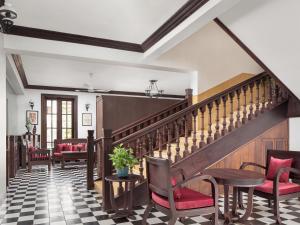 a lobby with stairs and chairs and a table at Chateau d'Angkor La Residence in Siem Reap