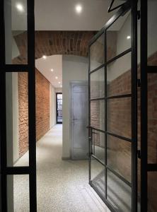 a hallway with a glass door and a brick wall at B4room in Bochnia