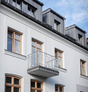 a white building with a balcony on it at B4room in Bochnia