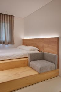 1 dormitorio con 1 cama y 1 silla en Mangrove Sinseol, en Seúl