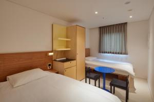 a hotel room with a bed and a table and chairs at Mangrove Sinseol in Seoul