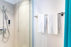 a bathroom with a shower and white towels at DaunTown Rooms - Self Check-In in Vienna