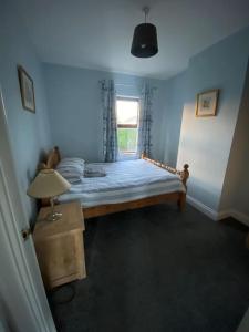 Dormitorio azul con cama y ventana en The Courtyard, en Newcastle