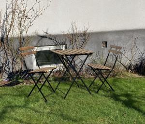 two chairs and a table in the grass at Blå Dörren in Höör