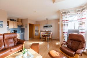 ein Wohnzimmer mit Ledermöbeln und eine Küche in der Unterkunft Wohnung 10 in Cuxhaven
