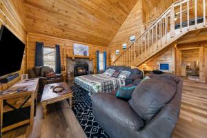 a living room with a couch and a staircase at Serenity, A Rustic Log Cabin Retreat in Sevierville