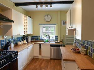 a kitchen with a sink and a clock on the wall at The Rockery in Shap