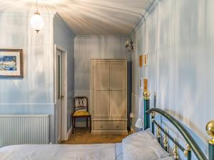 a bedroom with blue walls and a bed and a chair at The Rockery in Shap