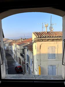 a view from a window of a street with buildings at Studio de charme au coeur de Valréas in Valréas