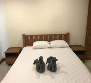 Zwei schwarze Rucksäcke sitzen auf einem Bett in der Unterkunft Khanom Beach Residence Condo - Spacious 1-bedroom in Khanom