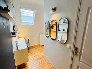 a room with two mirrors on the wall and a hallway at Appart Rouen Jardin des plantes in Rouen