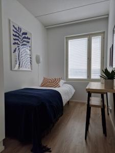 a bedroom with a bed and a table and window at Huhta Sport in Jyväskylä