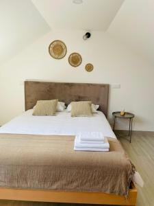 a bedroom with a large bed with two towels on it at Porto Smart Apartments Comfort in Perafita
