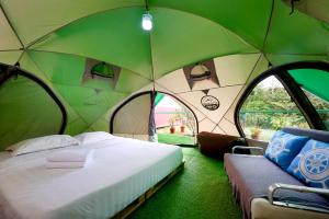 雲頂高原的住宿－Glamz at Genting，帐篷内的卧室,配有一张床和两个窗户