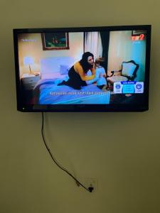 uma televisão de ecrã plano pendurada numa parede em Hotel Lavender Inn em Malaca