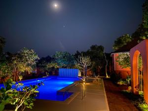 a swimming pool at night with the moon in the sky at Habitus - Mandrem in Mandrem