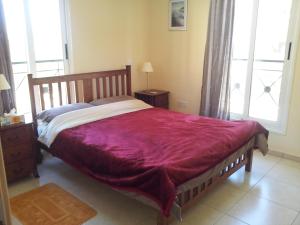 a bedroom with a large bed with a red blanket at Mazotos Panoramic Village in Mazotos