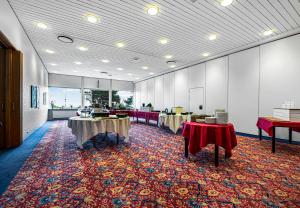a large room with tables and chairs on a rug at Hotel/ Apartments Marina in Grenå