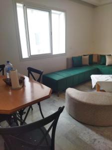 a living room with a green couch and a table at Adam beautiful loft in Nabeul +4 photos
