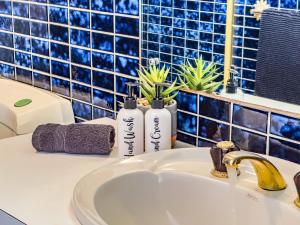a bathroom sink with two bottles on a counter at Blue Bay Beach Stay - Mandurah in Mandurah +60 photos