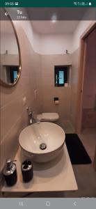 La salle de bains est pourvue d'un lavabo blanc et d'un miroir. dans l'établissement B&B Zia Vivina, à Sorico