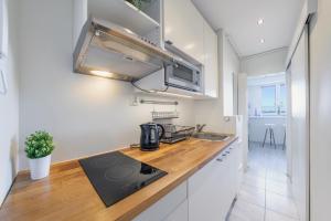 a kitchen with a sink and a stove top oven at Apartamenty Sun & Snow Partyzantów in Gdynia