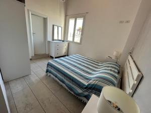 Dormitorio pequeño con cama y lavamanos en A 100metri dal mare difronte alla torre saracena. en Campomarino
