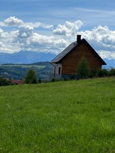 an old house on a hill in a field of grass at View & Spa Villa in Kluszkowce