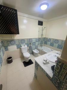 a bathroom with a toilet and a sink and a tub at Majorel Perle Hôtel Riad Restaurant Picine & Spa in Marrakesh