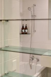 a bathroom with a glass shower with two bottles on a shelf at Mangrove Sinseol in Seoul