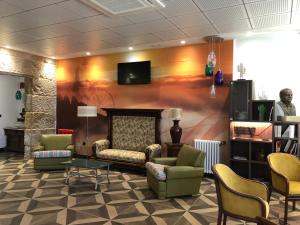 a waiting room with chairs and a tv on a wall at Hotel Villa México in Faramentaos
