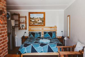- une chambre avec un lit bleu dans l'établissement Rusthof Accommodation, à Gansbaai