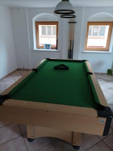 una mesa de billar verde en una habitación con ventanas en Monteurzimmer en Dresden