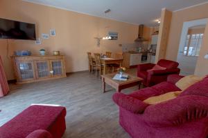 a living room with two red couches and a kitchen at Villa-Senta-Apartment-1 in Kühlungsborn