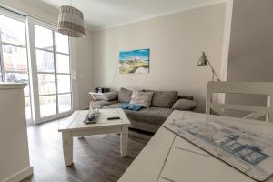 uma sala de estar com um sofá e uma mesa em Villa-Borwin-Apartment-1 em Kühlungsborn