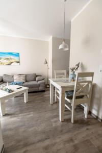 uma sala de estar com uma mesa e um sofá em Villa-Borwin-Apartment-1 em Kühlungsborn