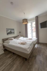 um quarto com uma grande cama branca e uma janela em Villa-Borwin-Apartment-1 em Kühlungsborn