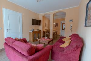 a living room with a pink couch and a table at Villa-Senta-Apartment-2 in Kühlungsborn
