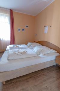 Schlafzimmer mit einem Bett mit weißer Bettwäsche und einem Fenster in der Unterkunft Villa Senta Apartment 2 in Kühlungsborn