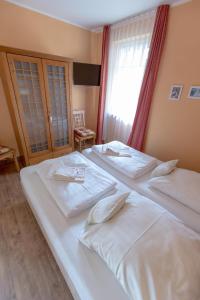 2 weiße Betten in einem Zimmer mit Fenster in der Unterkunft Villa Senta Apartment 2 in Kühlungsborn